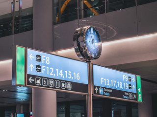 a sign with a clock at istanbul airport in turkey
