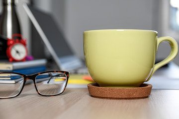 Office table desk. Workspace with glasses, cup of coffee, computer and notebooks. Break in the office work