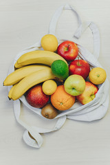 ECO-bag with colored fruits on a white table. Juice and smoothie ingredients. Healthy eating, diet concept