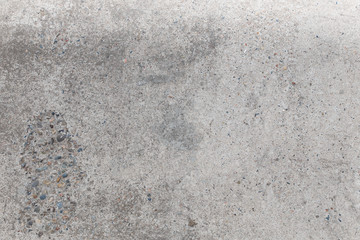 The gray texture of the concrete. A concrete surface with lines, dots, stones, and holes in the concrete. Abstract grey grunge background.