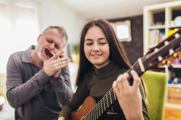 Family playing musical instruments at home having fun.