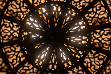 Lit, Moroccan, Arabian brass lamp with intricate decor.