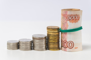 five thousand dollar bills and coins on a white background