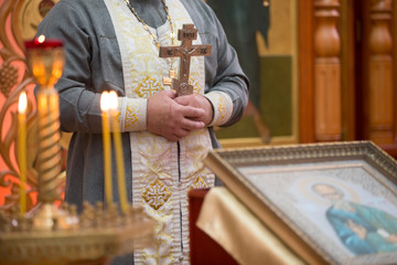 Obraz premium Priest with a cross on the background of the icon.