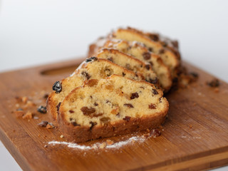 Cupcake with raisins sliced ​​on a wood. Cupcake sprinkled with powdered sugar. Homemade baking. Delicious food.