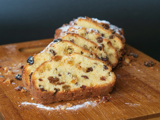 Cupcake with raisins sliced ​​on a wood. Cupcake sprinkled with powdered sugar. Homemade baking. Delicious food.