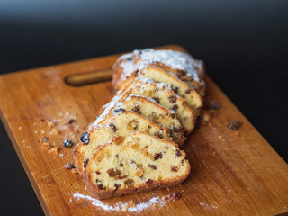 Cupcake with raisins sliced ​​on a wood. Cupcake sprinkled with powdered sugar. Homemade baking. Delicious food.