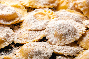 Tasty raw ravioli with flour and basil on wood table