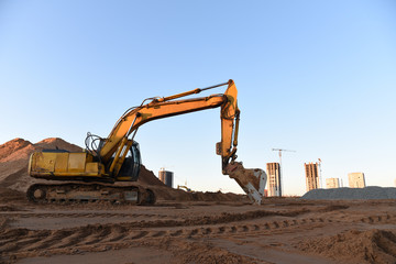 Track-type excavator during earthmoving at construction site. Backhoe digg ground at construction...