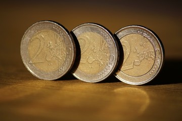Two euro coins on wooden board