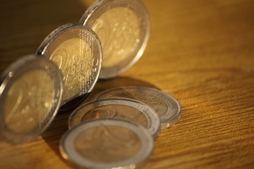 Two euro coins on wooden board