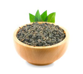 Dry oolong tea leaf and tea in wooden bowl on white background