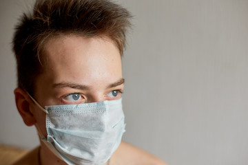 self-isolation and quarantine, portrait of a teenage boy in a medical mask, protection from viruses and diseases