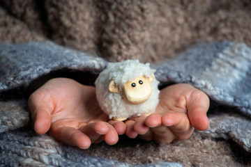 Little kid is holding the easter lamb – decoration for Easter holiday