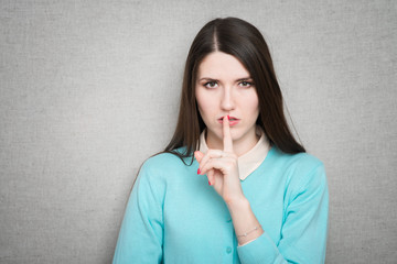 Portrait of beautiful woman with finger on lips, isolated
