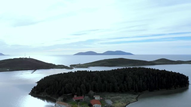 Zvernec island with medieval church and monastery, pine trees forest at sunset with cloudy sky