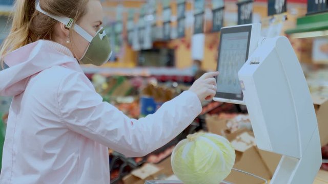a masked woman weighs vegetables in a store