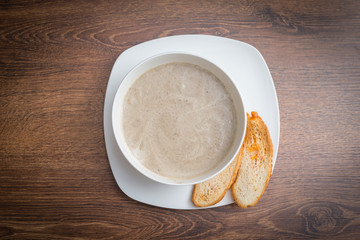 Mushroom cream soup on wooden board.