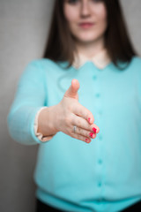 Portrait of positive business woman stretching her hand for a handshake isolated