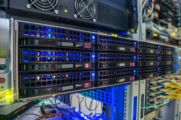 A modern computer server with many hard drives is a close-up. Powerful computing equipment works in a data center rack. Information technology concept
