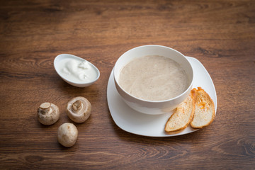 Mushroom cream soup on wooden board.