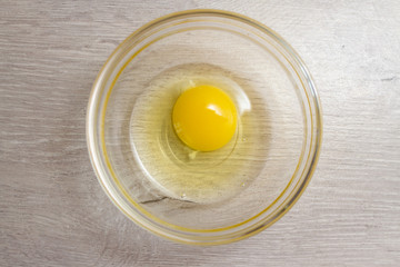 chicken yolk in a transparent bowl on the kitchen table