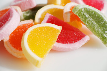 Tasty sweet marmalade in the shape of fruit slices on a white background