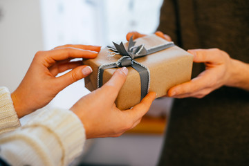 young woman gives a gift in a box