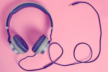 Wired headphones in khaki on a pink background.Vintage and retro.