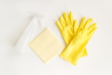 disinfection kit on a white background yellow rag, yellow gloves and white disinfectant. to combat coronavirus