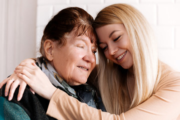 Fototapeta na wymiar Happy old grandmother hugging grandchild girl looking at camera, smiling mature mother, headshot portrait