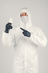 Fototapeta na wymiar A man in a medical protective mask, holding a hand sanitizer.