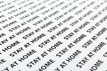 Black plain text on white paper about coronavirus outbreak. Quarantine. Stay at home.