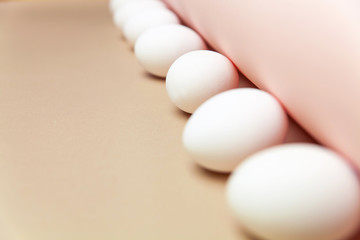 Creative Easter beige and pink background with white eggs.