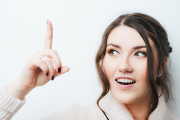 on a white background girl shows the index finger up