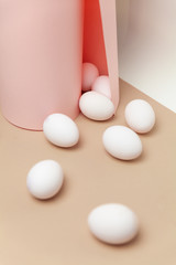 Creative Easter beige and pink background with white eggs.