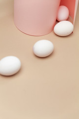 Creative Easter beige and pink background with white eggs.