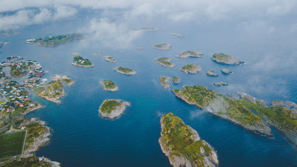 Aerial view of Henningsvaer archipelago and famous football stadium on Lofoten islands in clouds