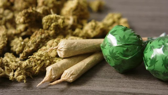 Cannabis buds on a table. Close-Up of two joints and weed lollipops