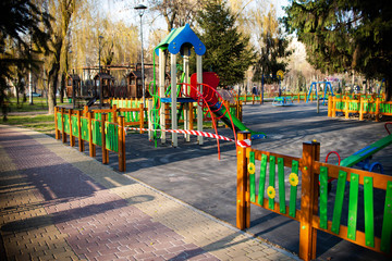 It?s impossible to enter the playground with a safety tape. Entrance to the play area outside the park is prohibited. Coronavirus. Virus. Children cannot play.