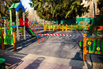It?s impossible to enter the playground with a safety tape. Entrance to the play area outside the park is prohibited. Coronavirus. Virus. Children cannot play.