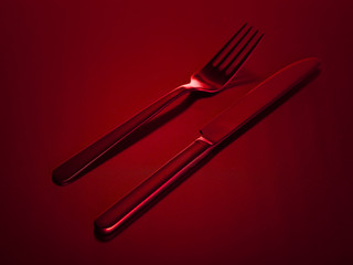 Red knife and fork on a red beautiful background. You can change the color.