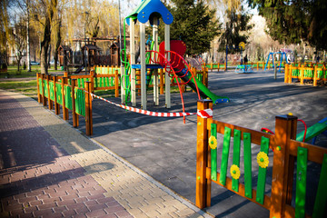 It?s impossible to enter the playground with a safety tape. Entrance to the play area outside the park is prohibited. Coronavirus. Virus. Children cannot play.