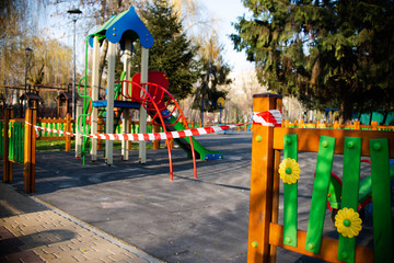 It?s impossible to enter the playground with a safety tape. Entrance to the play area outside the park is prohibited. Coronavirus. Virus. Children cannot play.