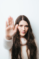 Naklejka premium on a white background young girl with long hair shows stop