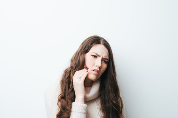 beautiful long-haired girl a toothache on a white background