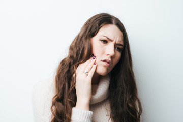 on a white background a young girl with long hair toothache - obrazy, fototapety, plakaty