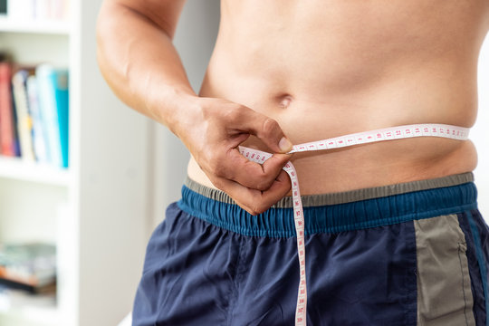 Muscular male man torso with measuring tape, weight loss and dieting concept