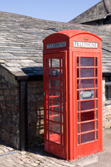 Bibury (England), UK - August 05, 2015: A red phone box in Bibury village, Gloucestershire, England, United Kingdom.
