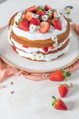 Strawberry cake, strawberry sponge cake with fresh strawberries and sour cream on a white background
